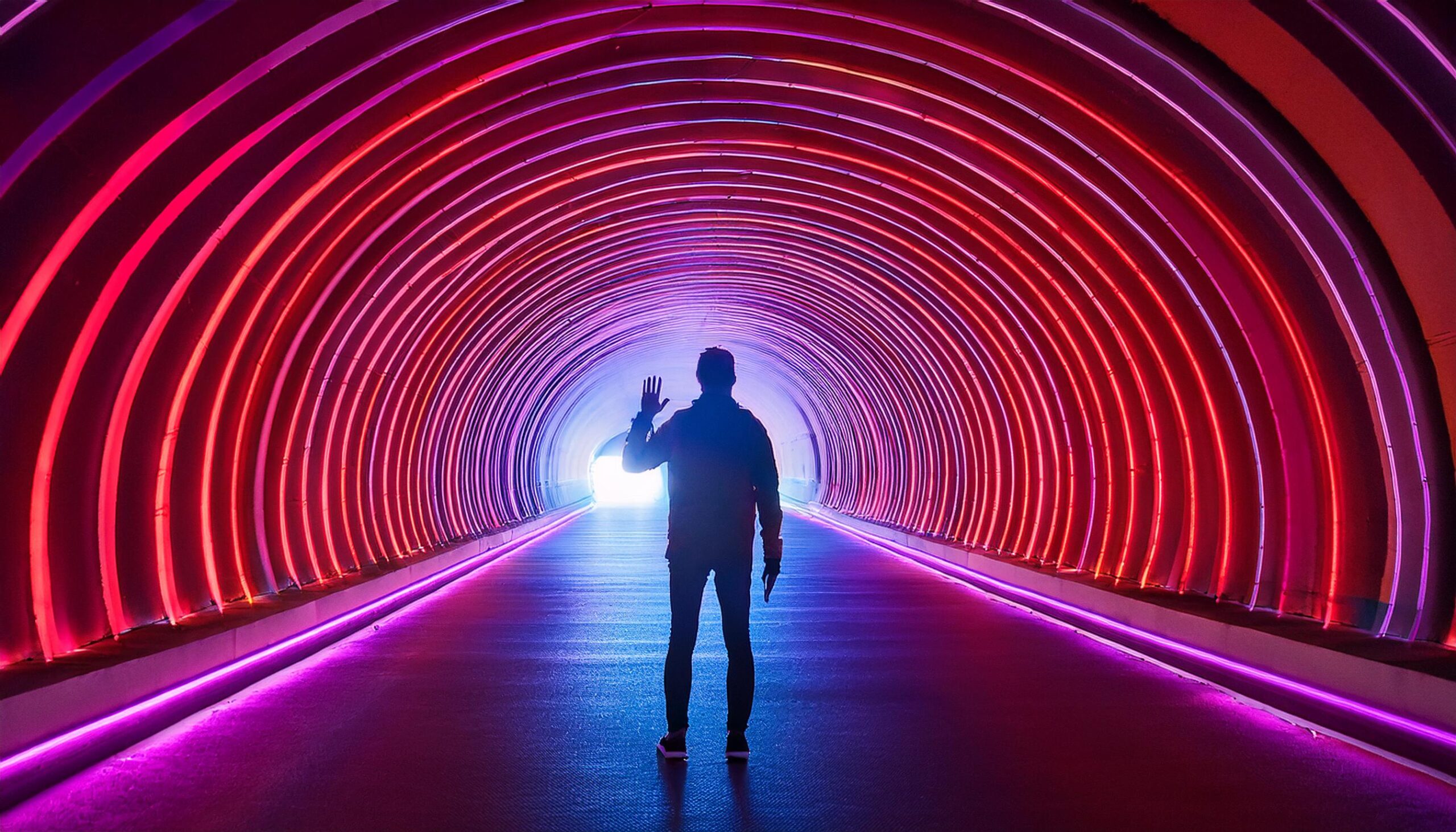 A tunnel surrounded by neon red and purple lights.