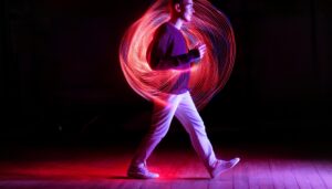 A young person walking surrounded by neon lights. background is in tones of red and purple